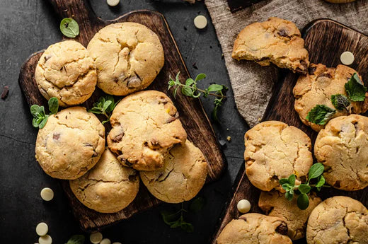 Soft Chewy Delectable Chocolate Chip VEEG Protein Cookies placed on platters with mint leaves and white chocolate chips